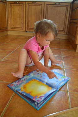 Малышка и книга - иллюстрация к статье о том, как помочь ребёнку запоминать стихи