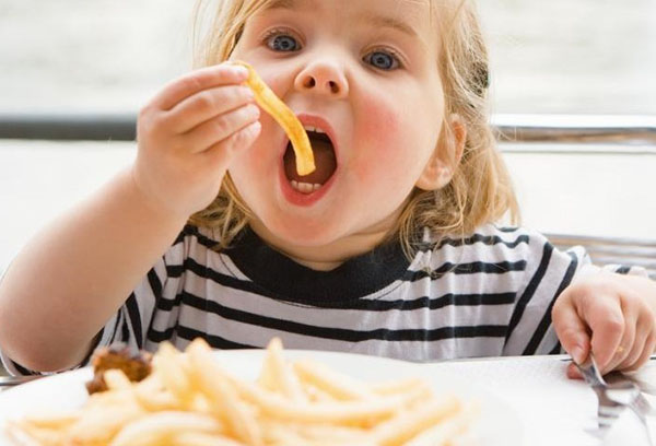 Девочка ест картофель фри