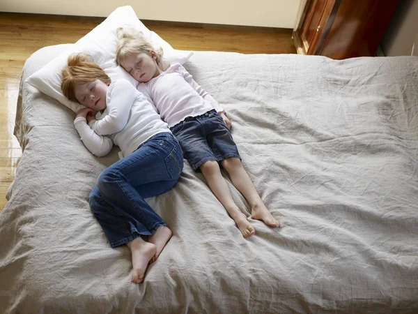 Маленькие сестры на кровати — стоковое фото