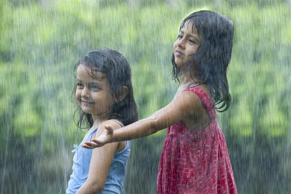 Девушки, стоя под дождем — стоковое фото