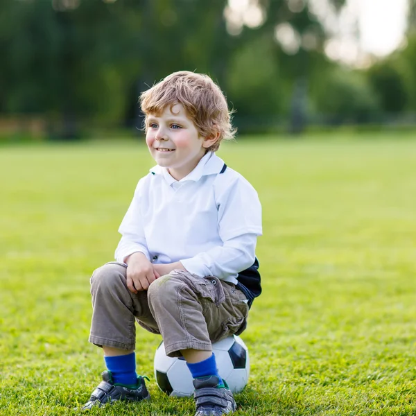 Блондинка мальчик 4 отдыхает с футбол на футбольном поле — стоковое фото